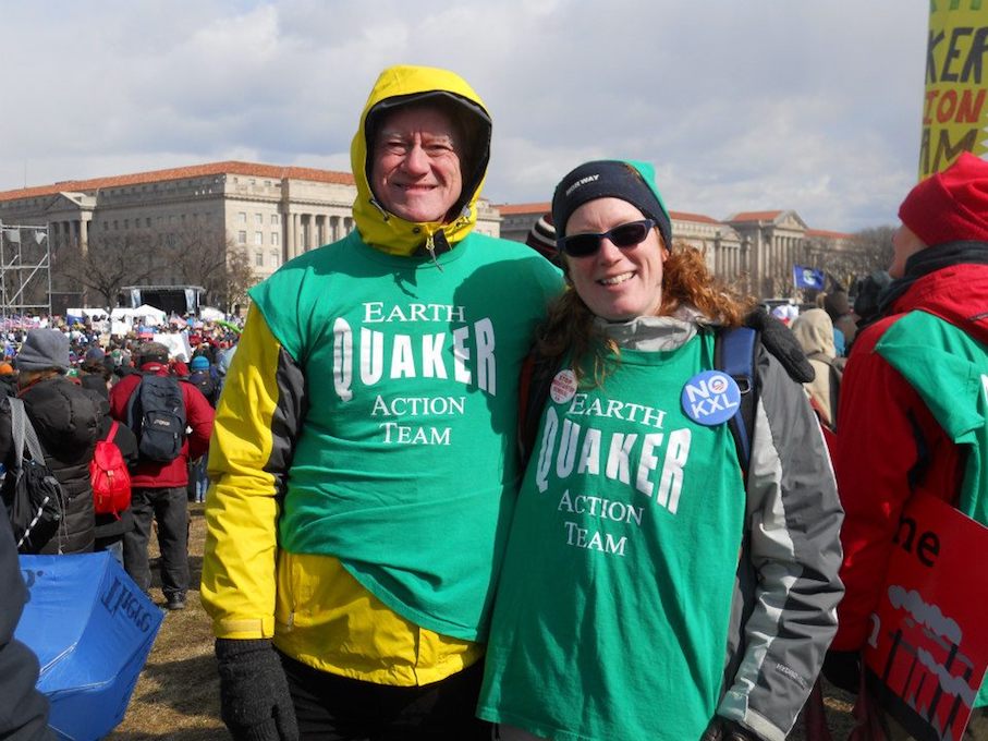 George and Ingrid Lakey stand with their arms around each other at a rally at the U.S Capitol. They wear green t-shirts reading "Earth Quaker Action Team."